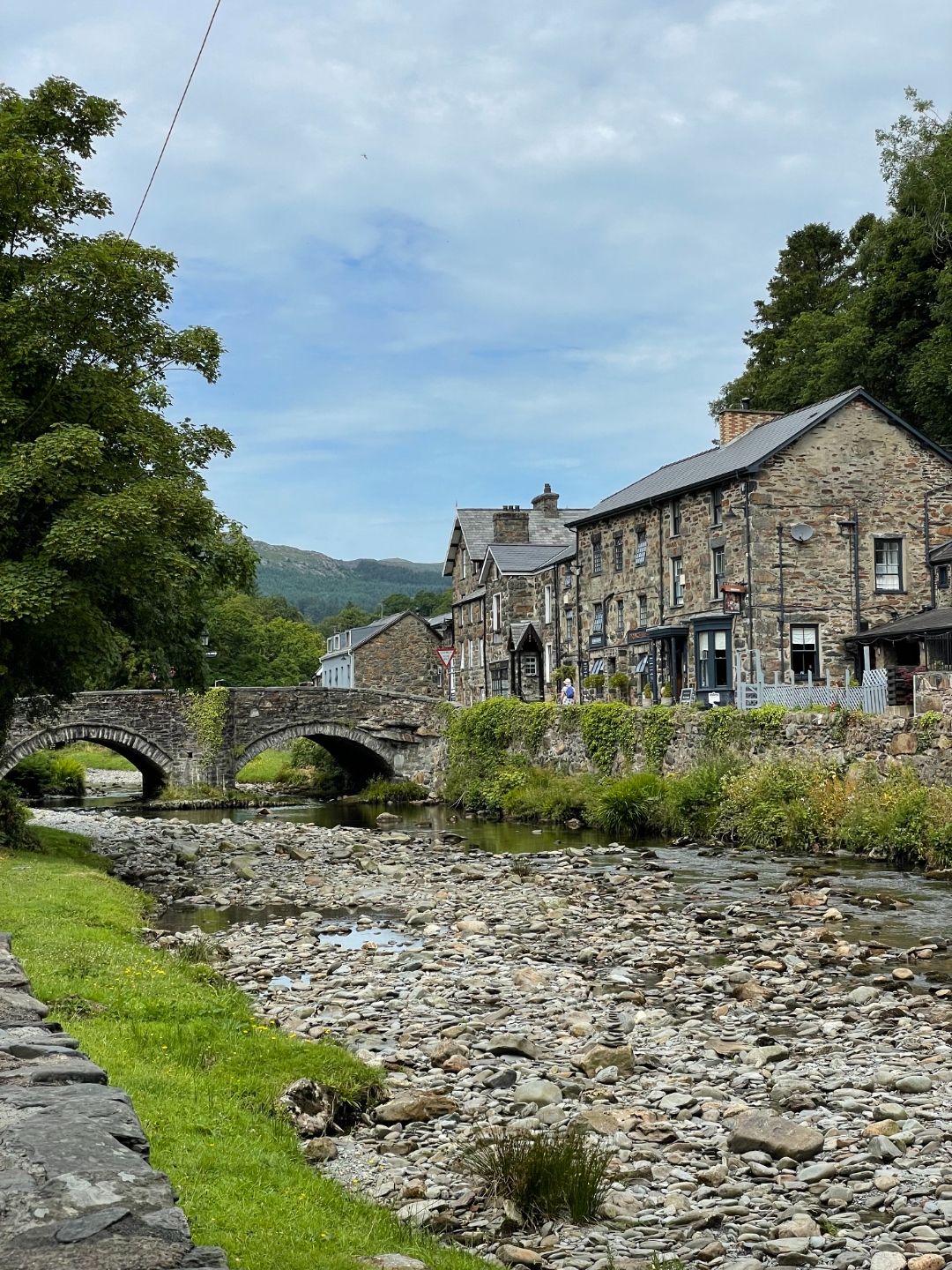 Stone bridge and village of Beddgelert beside a rocky stream