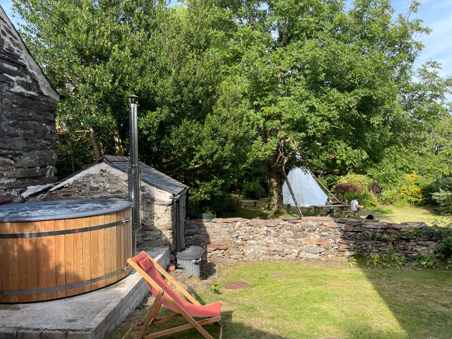 Wider view of garden with hot tub and tipi