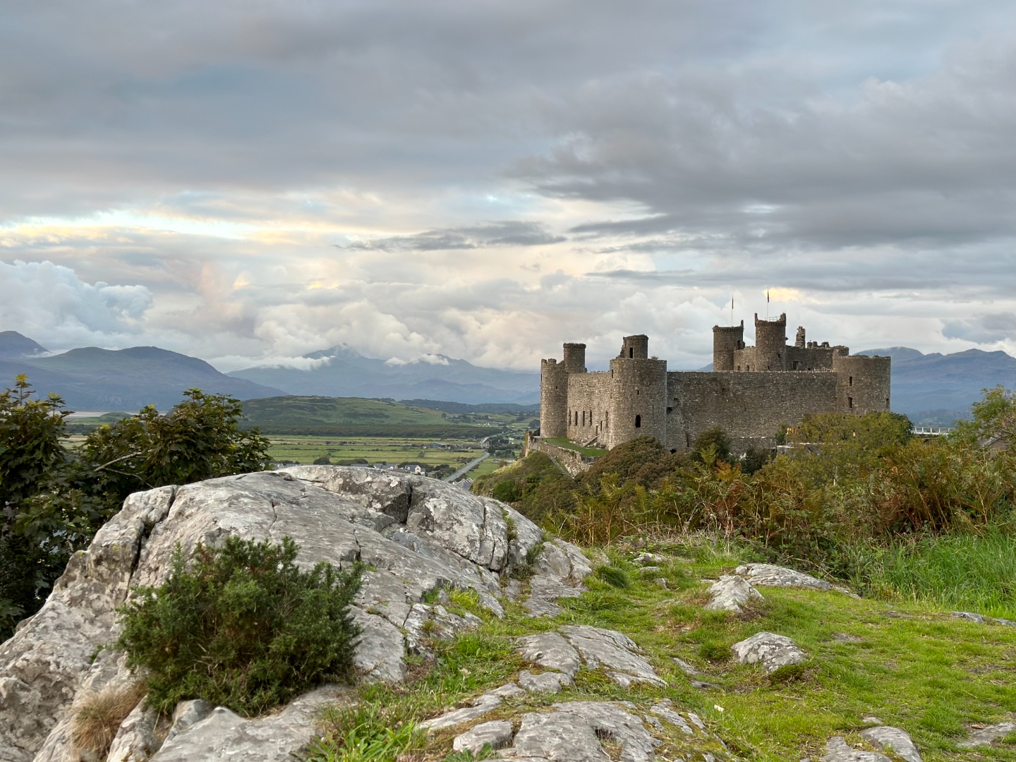 Harlech Castle from rocky hillside with Snowdonia behind