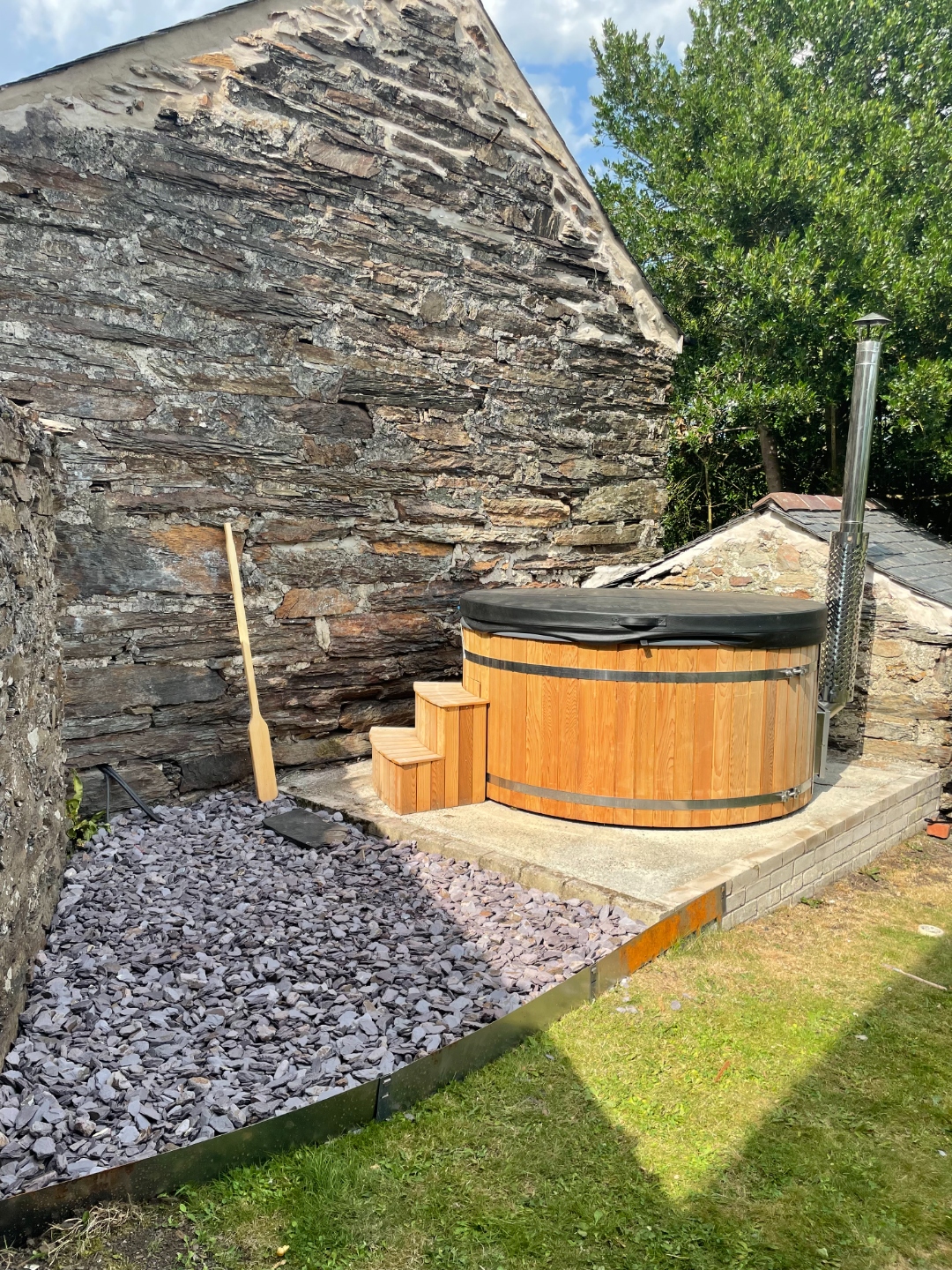 Cedar hot tub against stone gable wall